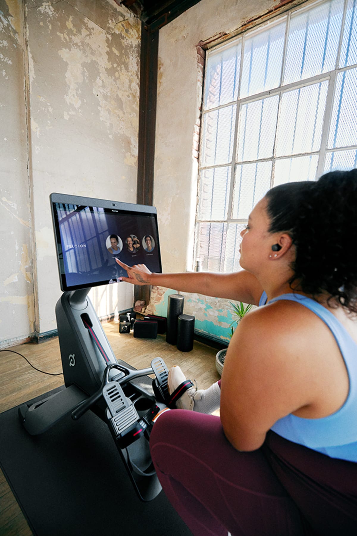 A person touching the Peloton Row screen