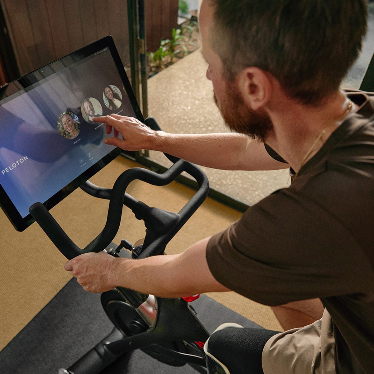 Member tapping Peloton All-Access Membership profile on Peloton Bike