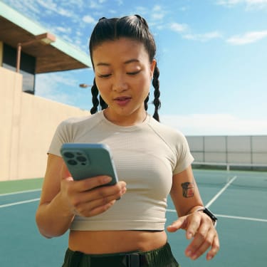 User holding phone with the Peloton App opened