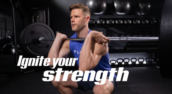 Coach Andy Speer squatting with a barbell with ignite your strength