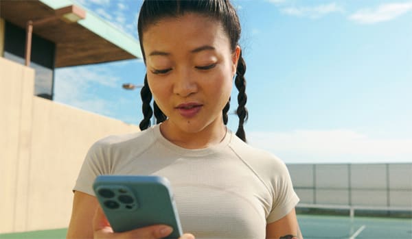 woman smiling down at her phone